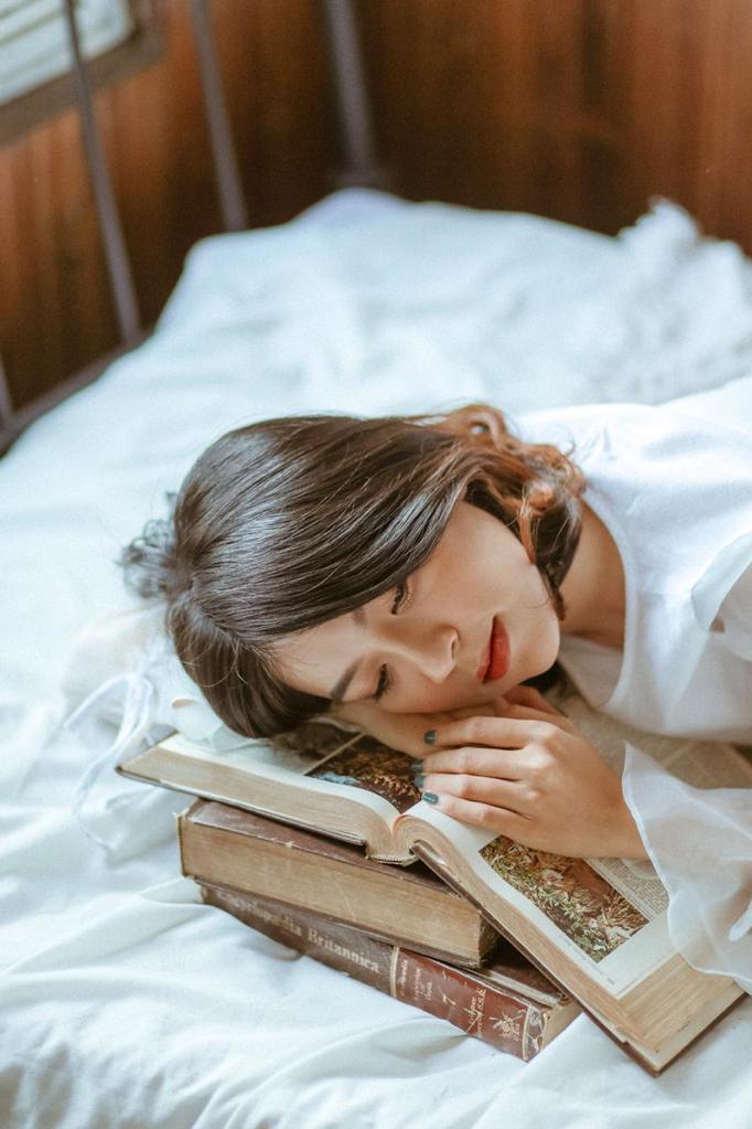 Vrouw slaapt op stapel boeken